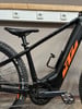 Ein schwarzes E-Bike mit orangefarbenem KTM-Logo und Flaschenhalter.