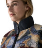 Frau in buntem Fleece-Pullover mit Patagonia-Logo vor weißem Hintergrund.