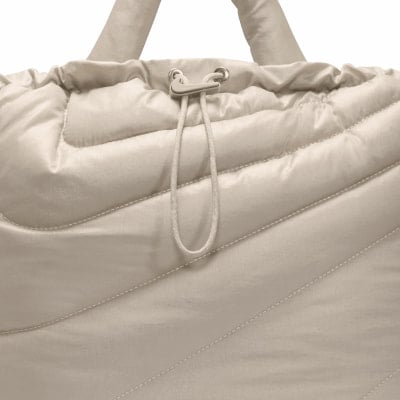 Detail einer gesteppten Tasche mit verstellbarem Kordelzug und Nike-Logo. Detail einer gesteppten Tasche mit verstellbarem Kordelzug und Nike-Logo.