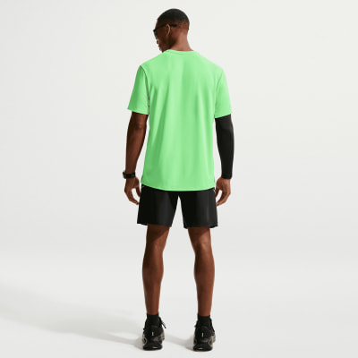 Rückansicht eines Mannes in einem neongrünen T-Shirt und schwarzer Hose.
