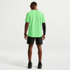 Rückansicht eines Mannes in einem neongrünen T-Shirt und schwarzer Hose.