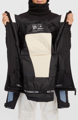 Innere Seite einer schwarzen Jacke mit cremefarbener Fleece-Innenseite und Logo.