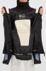 Innere Seite einer schwarzen Jacke mit cremefarbener Fleece-Innenseite und Logo.