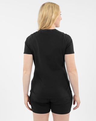Eine Frau in einem schwarzen T-Shirt und Shorts steht mit dem Rücken zur Kamera. Eine Frau in einem schwarzen T-Shirt und Shorts steht mit dem Rücken zur Kamera.