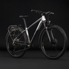 Ein Mountainbike mit Schutzblechen und Gepäckträger auf schwarzem Hintergrund.