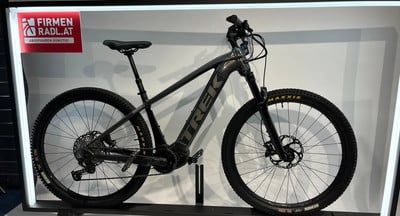 Graues Trek E-Bike mit Logo auf dem Rahmen auf einem Ständer. Graues Trek E-Bike mit Logo auf dem Rahmen auf einem Ständer.