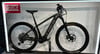 Graues Trek E-Bike mit Logo auf dem Rahmen auf einem Ständer.