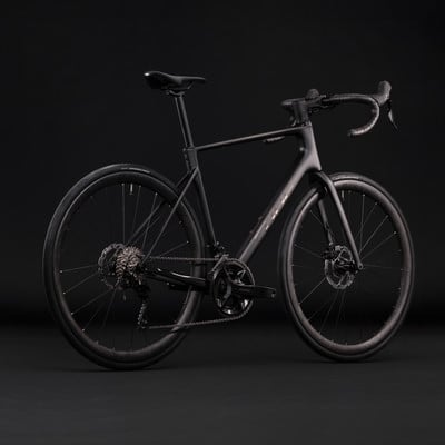 Schwarzes Rennrad mit Scheibenbremsen vor dunklem Hintergrund. Schwarzes Rennrad mit Scheibenbremsen vor dunklem Hintergrund.