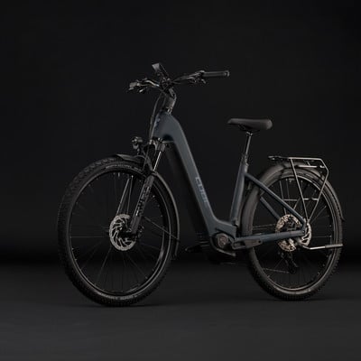 Graues Damen-E-Bike der Marke Cube mit Gepäckträger und Federung. Graues Damen-E-Bike der Marke Cube mit Gepäckträger und Federung.