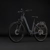 Graues Damen-E-Bike der Marke Cube mit Gepäckträger und Federung.