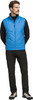 Ein Mann in einer blauen Weste und schwarzer Hose steht vor weißem Hintergrund.
