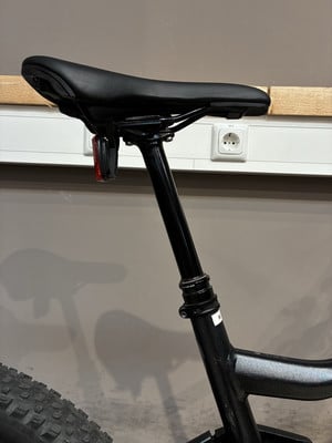 Ein Fahrradsattel mit einer Teleskop-Sattelstütze und rotem Licht. Ein Fahrradsattel mit einer Teleskop-Sattelstütze und rotem Licht.