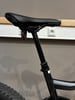 Ein Fahrradsattel mit einer Teleskop-Sattelstütze und rotem Licht.