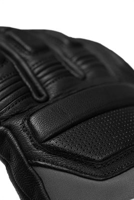 Detail einer schwarzen Lederhandschuhe mit Nähten und Perforation.