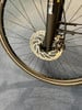 Detail eines Fahrradvorderrads mit Scheibenbremse und Gabel.