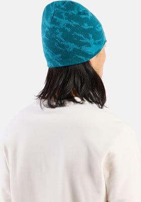 Ein Mann mit langen Haaren trägt eine blaue Strickmütze und einen weißen Pullover. Ein Mann mit langen Haaren trägt eine blaue Strickmütze und einen weißen Pullover.