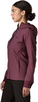 Frau in dunkelweinvogelroter Kapuzenjacke und schwarzer Hose, Seitenansicht. Frau in dunkelweinvogelroter Kapuzenjacke und schwarzer Hose, Seitenansicht.