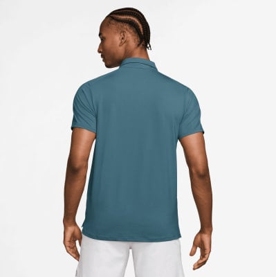 Mann in einem dunkelblauen Poloshirt mit kurzen Ärmeln und weißen Shorts.