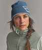 Frau mit blauer Mütze und grüner Jacke mit Zopf.