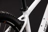 Detail des weißen Mountainbike-Rahmens mit Nahaufnahme der Sattelstütze und des Hinterrads.