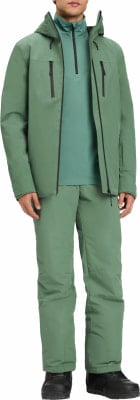 Ein Mann in einer grünen Skijacke und Hose mit schwarzen Reißverschlüssen. Ein Mann in einer grünen Skijacke und Hose mit schwarzen Reißverschlüssen.