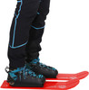 Person in Bergstiefeln und Skiern mit roten Laufflächen.