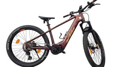 E-Bike KTM mit dunkelweinrotem Rahmen und schwarzen Rädern vor weißem Hintergrund. E-Bike KTM mit dunkelweinrotem Rahmen und schwarzen Rädern vor weißem Hintergrund.
