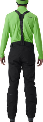 Ein Mann von hinten in einem grünen Skianzug und schwarzer Skihose mit Trägern. Ein Mann von hinten in einem grünen Skianzug und schwarzer Skihose mit Trägern.