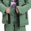 Detail einer grünen Winterjacke und Hose mit schwarzen Akzenten.