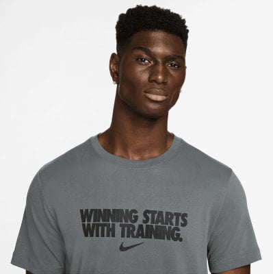 Ein Mann in einem grauen T-Shirt mit der Aufschrift „WINNING STARTS WITH TRAINING“. Ein Mann in einem grauen T-Shirt mit der Aufschrift „WINNING STARTS WITH TRAINING“.