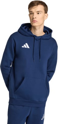 Ein Mann in einem dunkelblauen Kapuzenpullover mit Adidas-Logo, die Hände in den Taschen. Ein Mann in einem dunkelblauen Kapuzenpullover mit Adidas-Logo, die Hände in den Taschen.