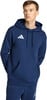 Ein Mann in einem dunkelblauen Kapuzenpullover mit Adidas-Logo, die Hände in den Taschen.
