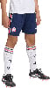Ein Kind in dunkelblauen Shorts mit Streifen, weißen Socken und Fußballschuhen.