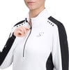 Eine Frau in einer weißen Jacke mit Reißverschluss und schwarzen Ärmelstreifen.