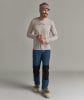 Ein Mann in einem Langarmshirt und blauen Hosen mit schwarzen Einsätzen und Skischuhen.