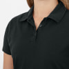 Detail eines schwarzen Damen-Poloshirts mit Kragen und Knöpfen.
