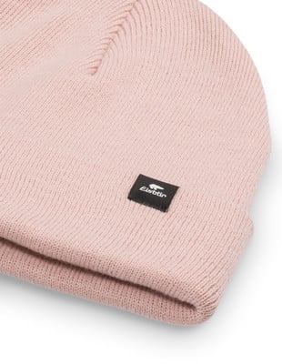 Eine hellrosa Strickmütze mit schwarzem Logo-Patch.