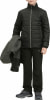 Ein Junge in einer schwarzen Daunenjacke und Hose hält eine Jacke.
