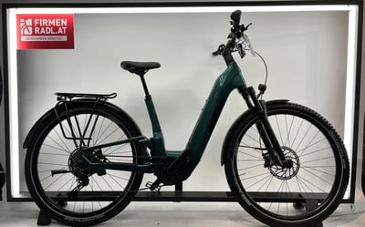 Ein grünes KTM E-Bike mit Gepäckträger und Schutzblechen steht im Showroom. Ein grünes KTM E-Bike mit Gepäckträger und Schutzblechen steht im Showroom.