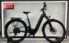 Ein grünes KTM E-Bike mit Gepäckträger und Schutzblechen steht im Showroom.