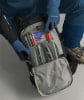 Eine Person verstaut eine Lawinenschaufel und Sonde in einem Rucksack.