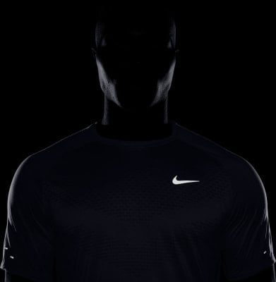 Mann in schwarzem Nike-Shirt mit reflektierenden Elementen an den Ärmeln. Mann in schwarzem Nike-Shirt mit reflektierenden Elementen an den Ärmeln.