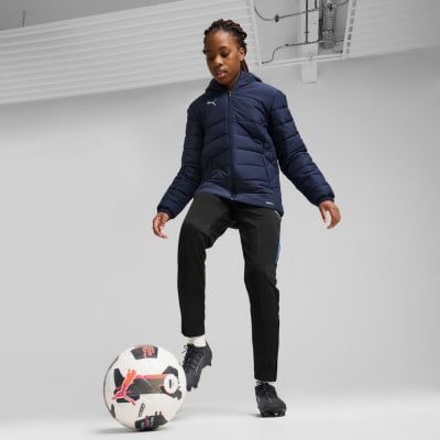 Mädchen in dunkelblauer Jacke und schwarzer Hose mit Fußball. Mädchen in dunkelblauer Jacke und schwarzer Hose mit Fußball.