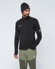 Mann in schwarzem Fleece und grüner Hose mit Mammut-Logo.