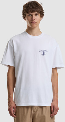 Ein Mann in einem weißen T-Shirt mit kleinem blauen Aufdruck und beige Shorts.