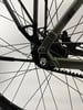 Detail eines Fahrradhinterrads mit Riemenantrieb und Mutter.