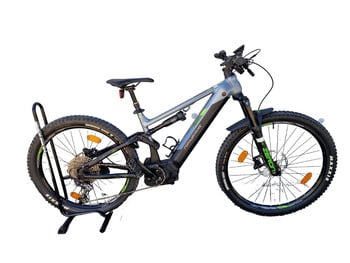 E-Mountainbike mit Federung, Ständer und Schutzblechen auf weißem Grund.