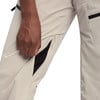 Hand in einer Hose mit schwarzem Reißverschluss und schwarzer Paspel.
