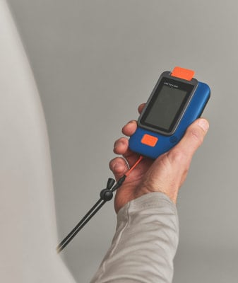Ein Mann hält ein blau-oranges Gerät mit einer Handschlaufe. Ein Mann hält ein blau-oranges Gerät mit einer Handschlaufe.