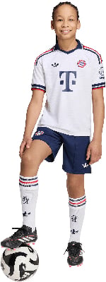 Fußballer in weißem Trikot mit blauem Logo und dunkelblauen Shorts.